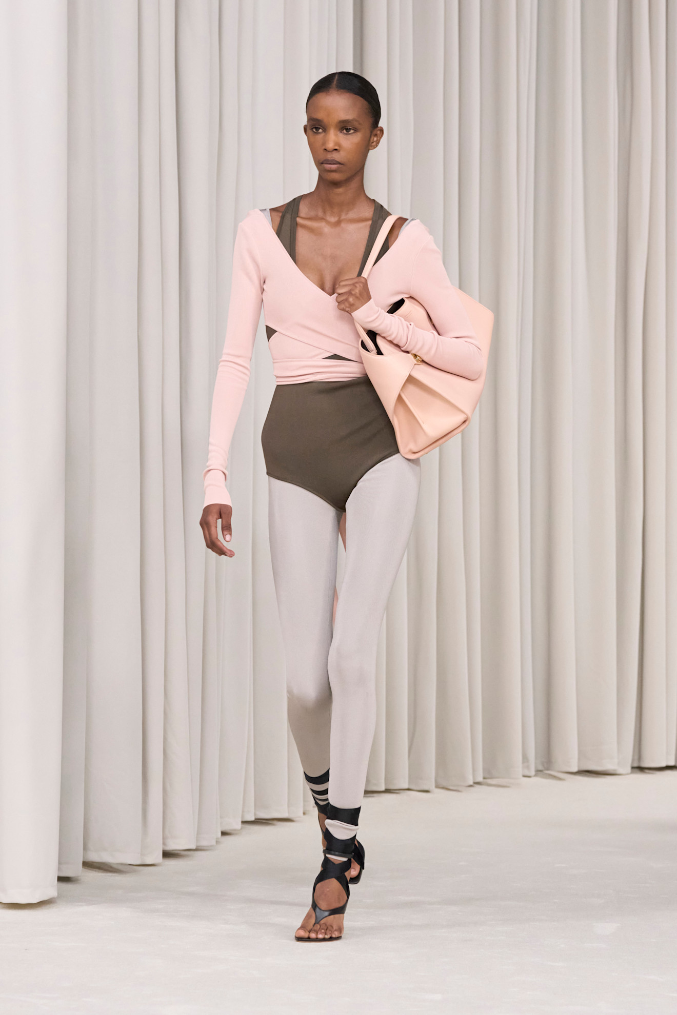 Model walks the Ferragamo spring/summer 2025 runway wearing a warp cardigan with a leotard and tights.