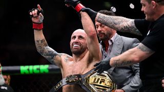 Alex Volkanovski, with the UFC title around his waist, celebrates a victory.