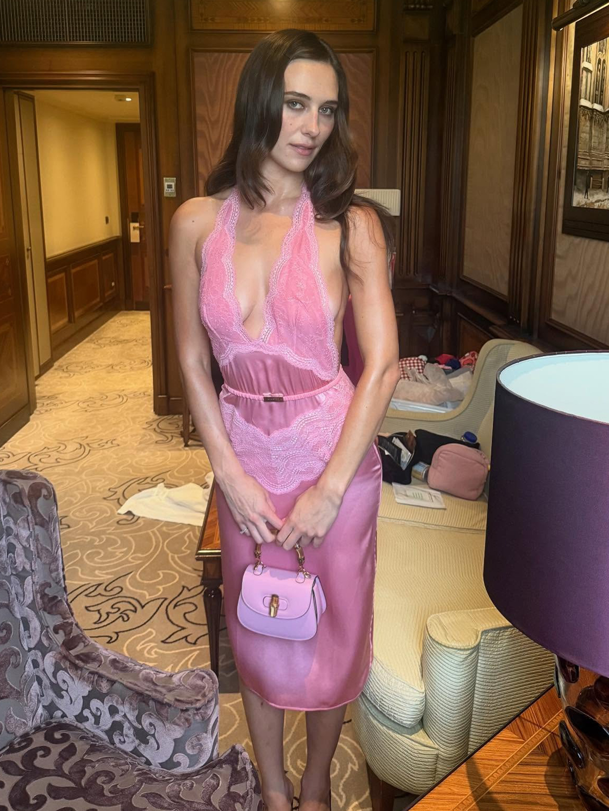 Devon Lee Carlson wearing a pink Gucci lace slip dress with a matching bag.