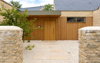 large modern wooden front door on timber and stone clad house