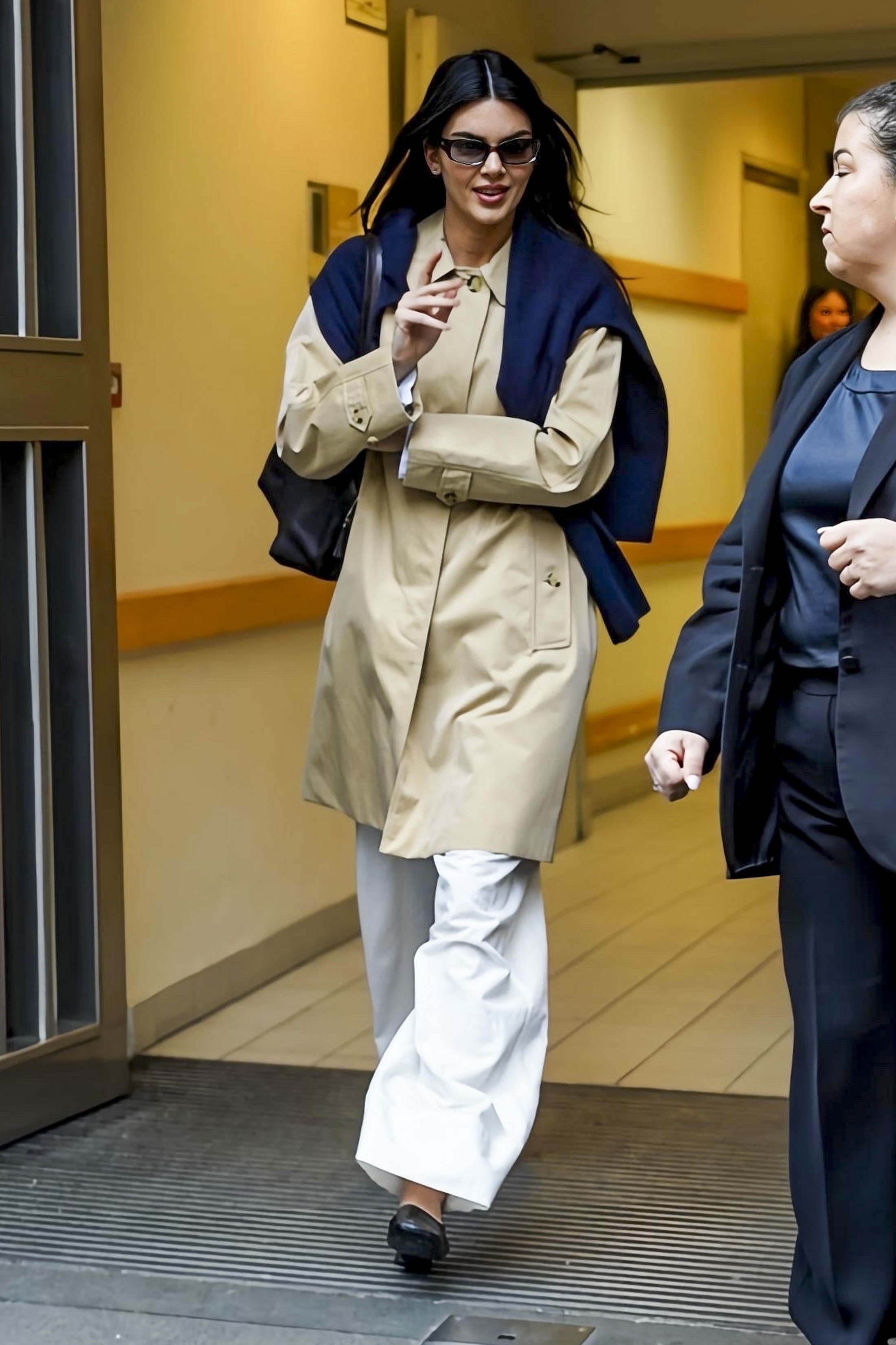 Kendall Jenner was spotted at Milan Fashion Week wearing wide-leg white pants, a Burberry trench coat, and the high-vamp flats trend