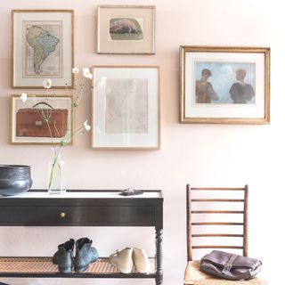 gallery wall in hallway with five pictures console table and chair