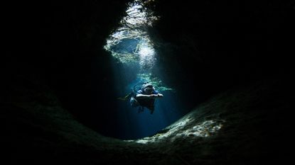 Scuba diver exploring underwater cave