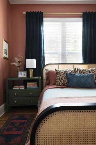 terracotta bedroom with cane bed and leopard print cushions