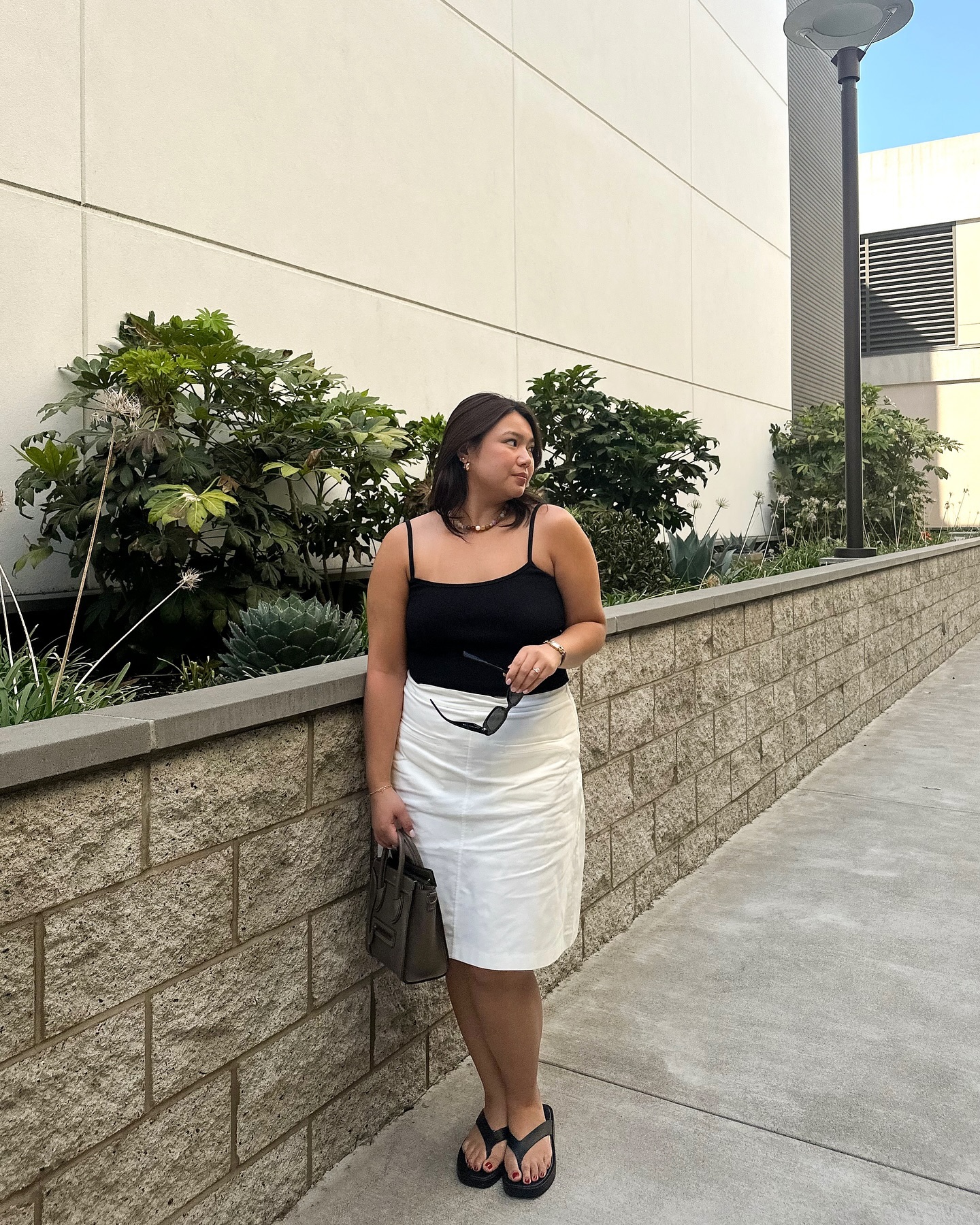 90s capsule wardrobe: @marina_torres wears a black tank top with a white skirt and flip-flops