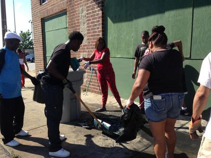 Milwaukee residents clean up their neighborhood after a night of violent protests