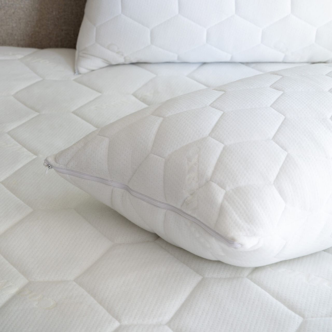 Soak &amp; Sleep Waterproof Coolmax Mattress Protector on a mattress with a hexagonal pattern