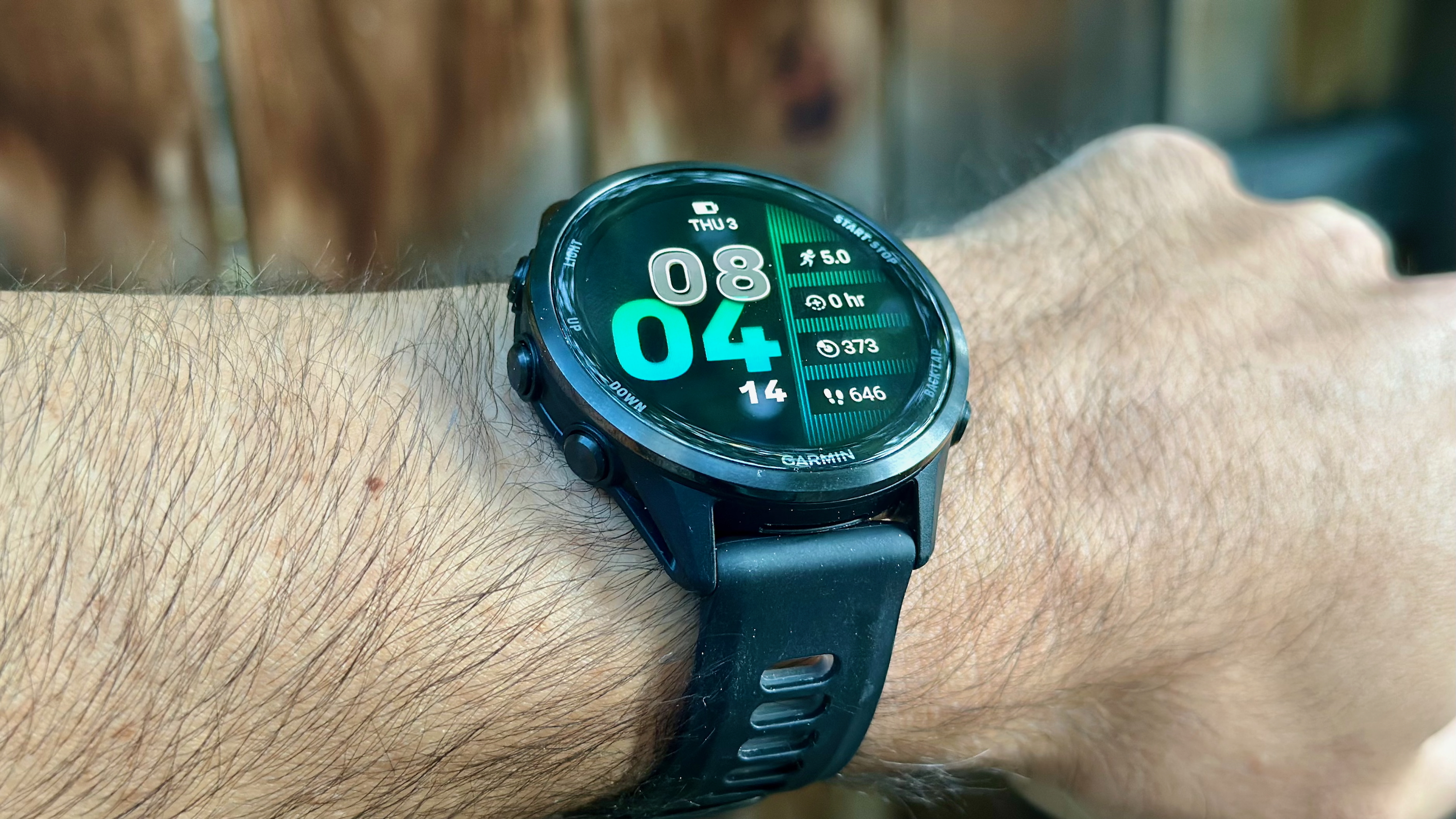 The Garmin Forerunner 970 worn on a wrist at an upward angle showing the default watch face.