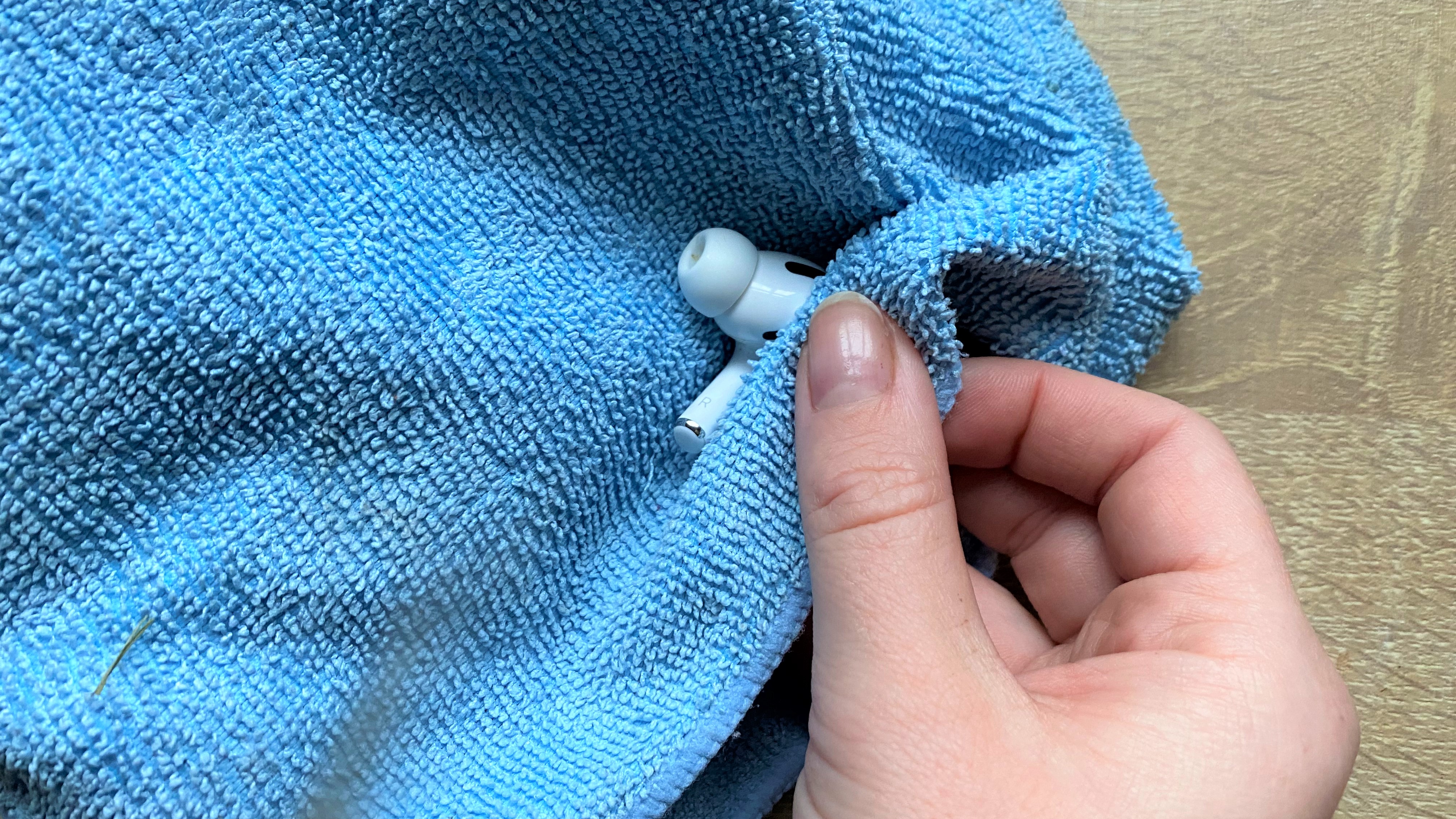 Using a cloth to clean the apple airpods pro