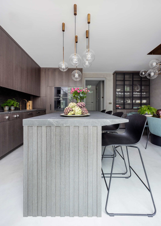 A concrete kitchen island with pendant lights