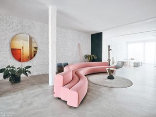 Warm colored mirrors in living room with curved sofa