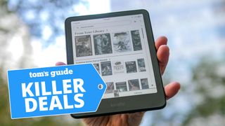Kindle Colorsoft held in hand with trees in background
