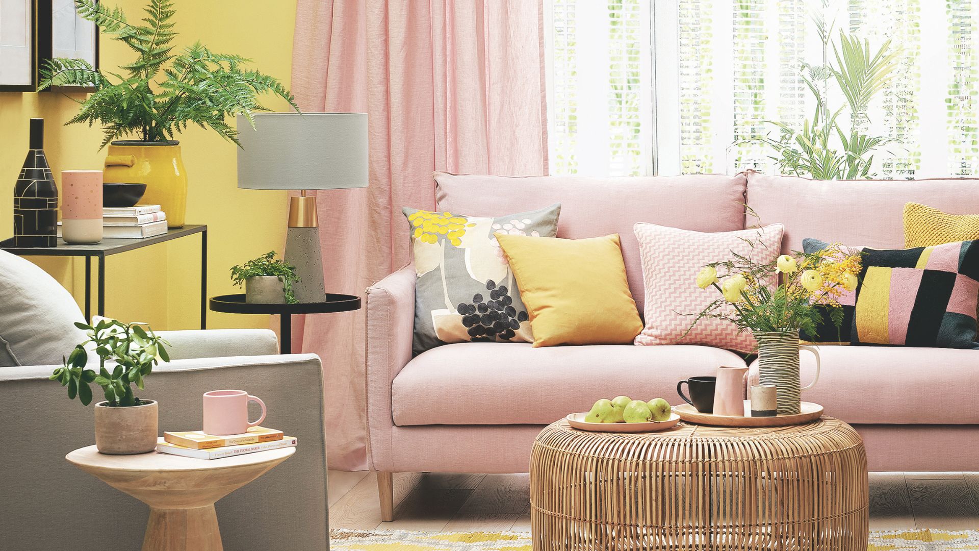 pink and yellow living room with wicker coffee table and decor