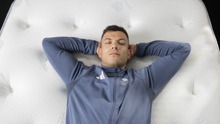 Team GB Olympic Skeleton competitor Matt Weston lying on his back on a Dreams Dream Team mattress
