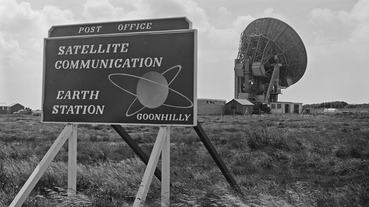 Sign at the entrance to the GPO Goonhilly Satellite Communication Earth Station, with a parabolic antenna in the background, on Goonhilly Downs in southern Cornwall, England, October 1965.