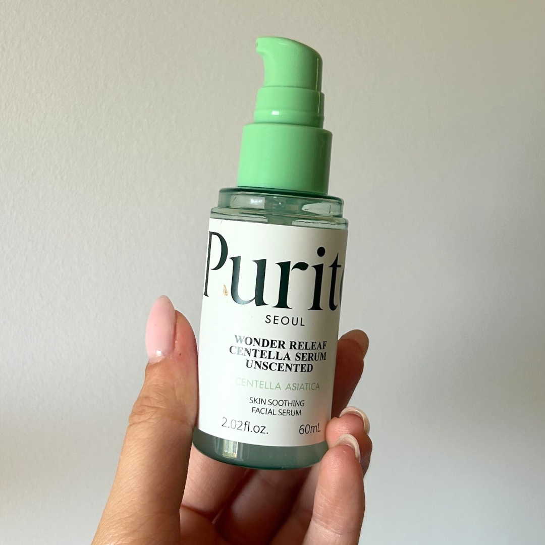 Hand holding empty bottle of Purito Centella Unscented Serum