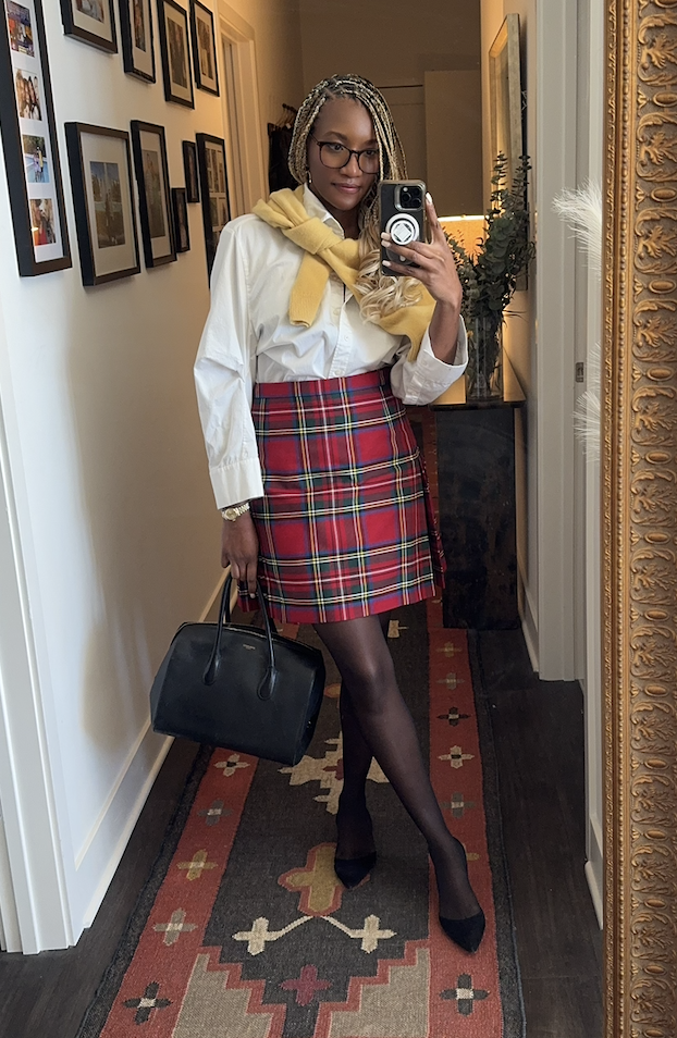 Danielle Prescod wearing a button-down, a plaid skirt, and a cardigan