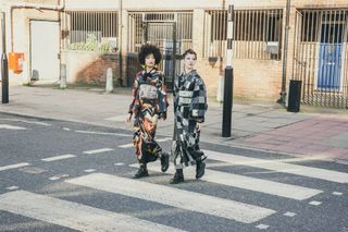 Two people wearing kimonos crossing the road at a zebra crossing