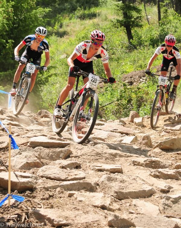 A trio of riders all attacking the downhill rock garden at the same time