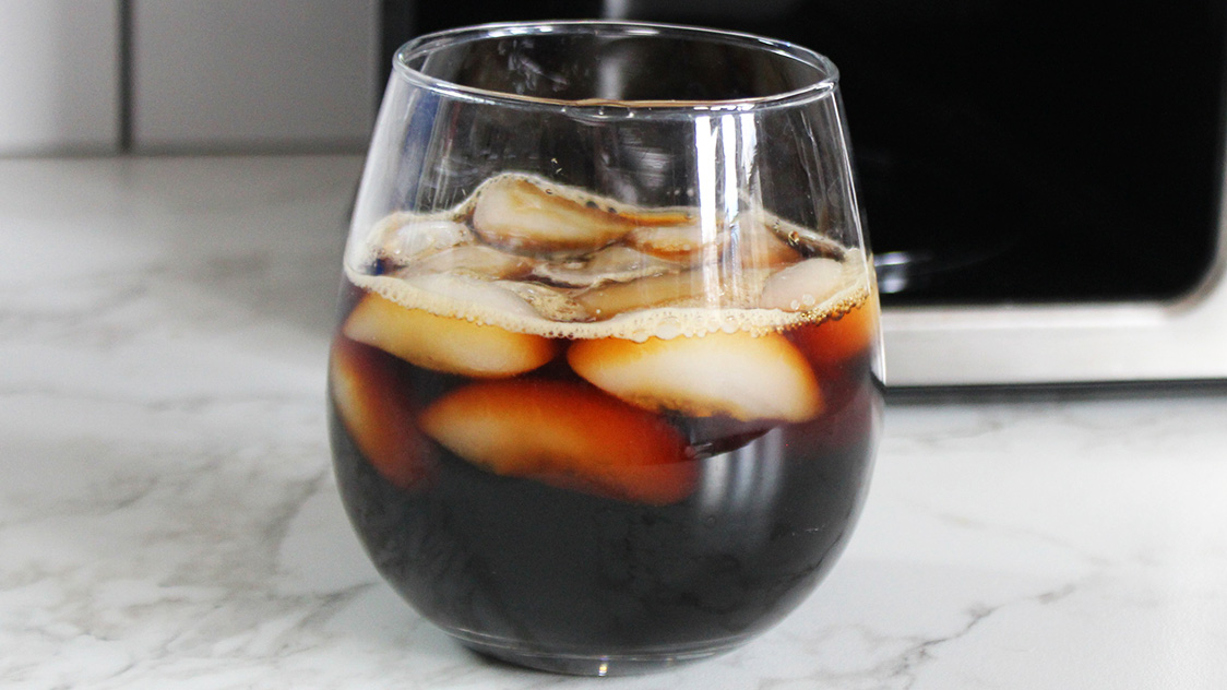 a black cold brew in a round glass