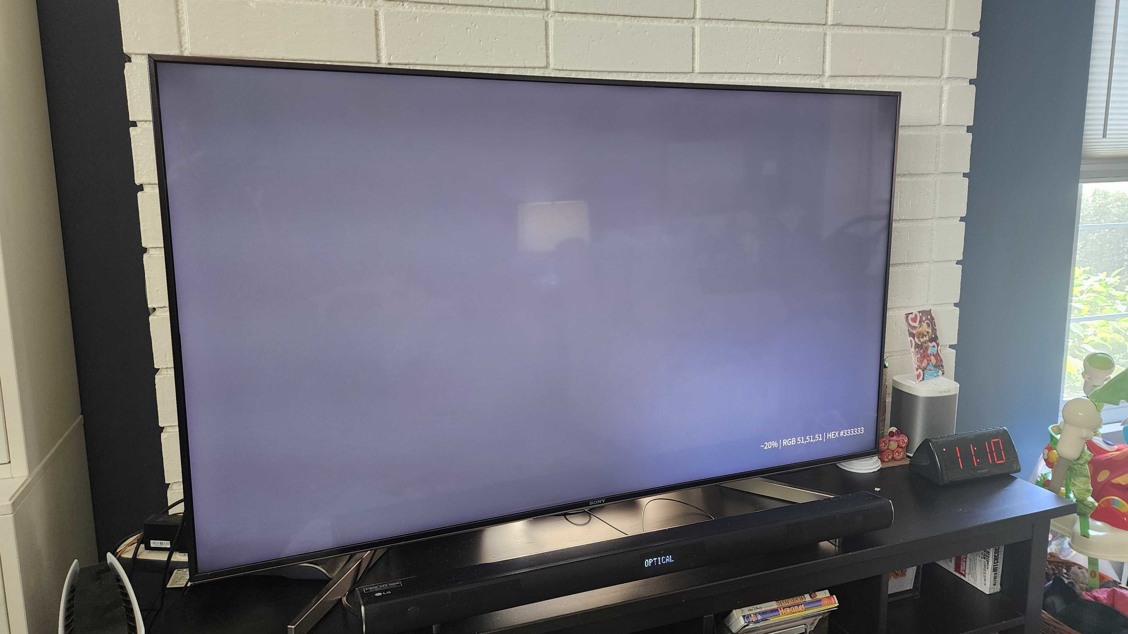 A Sony TV displaying a light gray-colored slide, which is helping to illuminate the panel's Dirty Screen Effect. Vignetting can be seen in the panel's corners and there are horizontal bands, as well.