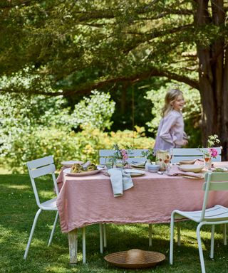 summery garden table dressed for lunch with pink linen tablecloth