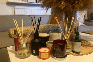 Home fragrance testing image with reed diffusers, candles and room sprays on coffee table