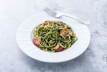 Vegan basil pesto courgetti with tomatoes and chilli
