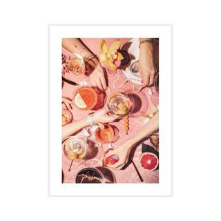 A picture of a pink dining table with food, drinks, and hands