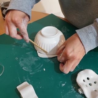 A rolled out piece of air dry clay being cut around the diameter of a bowl