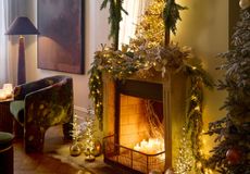 a fireplace decorated for Christmas with garlands and lights