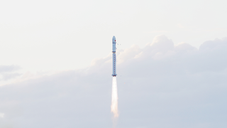 rocket lifting off with cloudy sky behind
