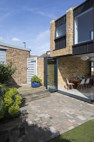 exterior of house with bi-fold doors open and the patio leading into the dining area