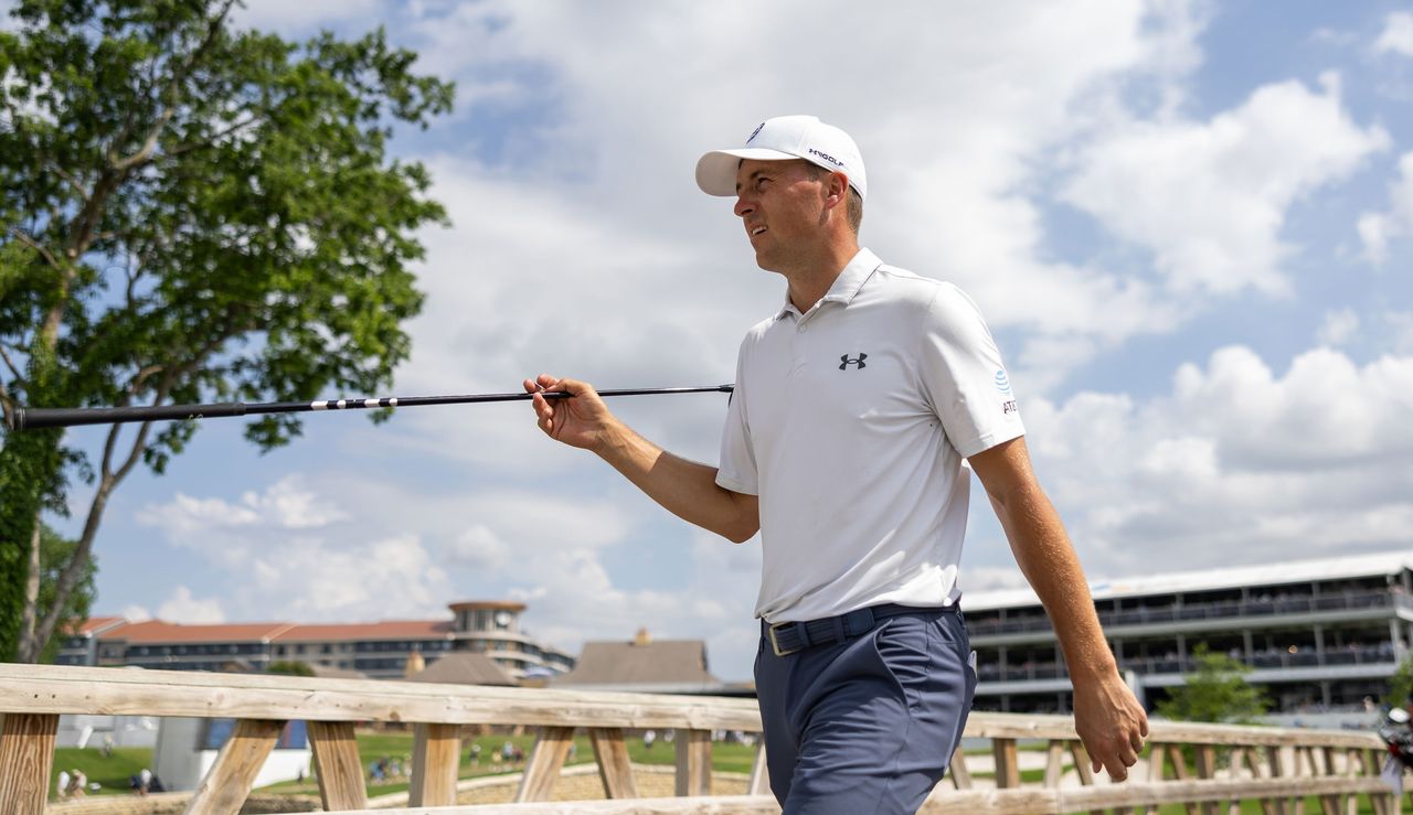 Jordan Spieth hands over his driver to his caddie