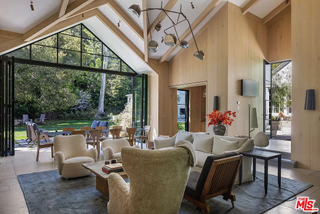 A living space with vaulted ceilings, wood clad walls, and Sherpa-style wing back arm chairs