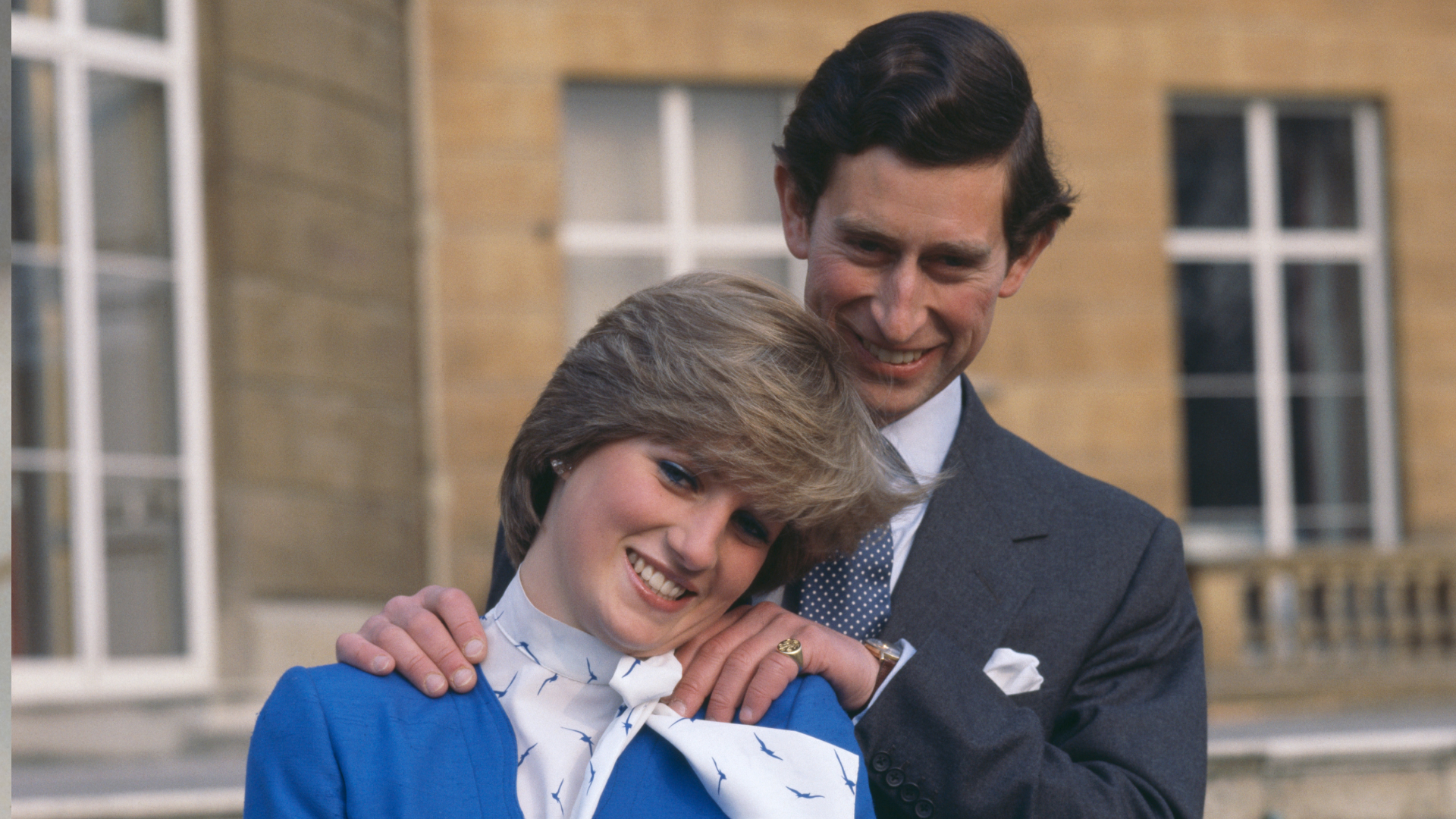 Prince Charles putting his hands on Princess Diana's shoulders during their engagement photoshoot in 1981