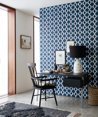 blue wallpapered home office with black furniture