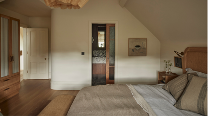 Beautiful loft conversion guest bedroom decorated in neutral tones and natural materials