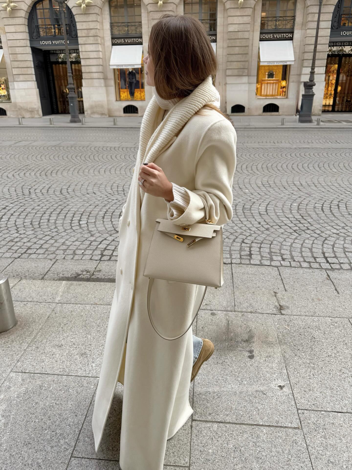 Woman in white coat and scarf with jeans
