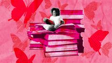 Woman sitting on top of a stack of books and reading