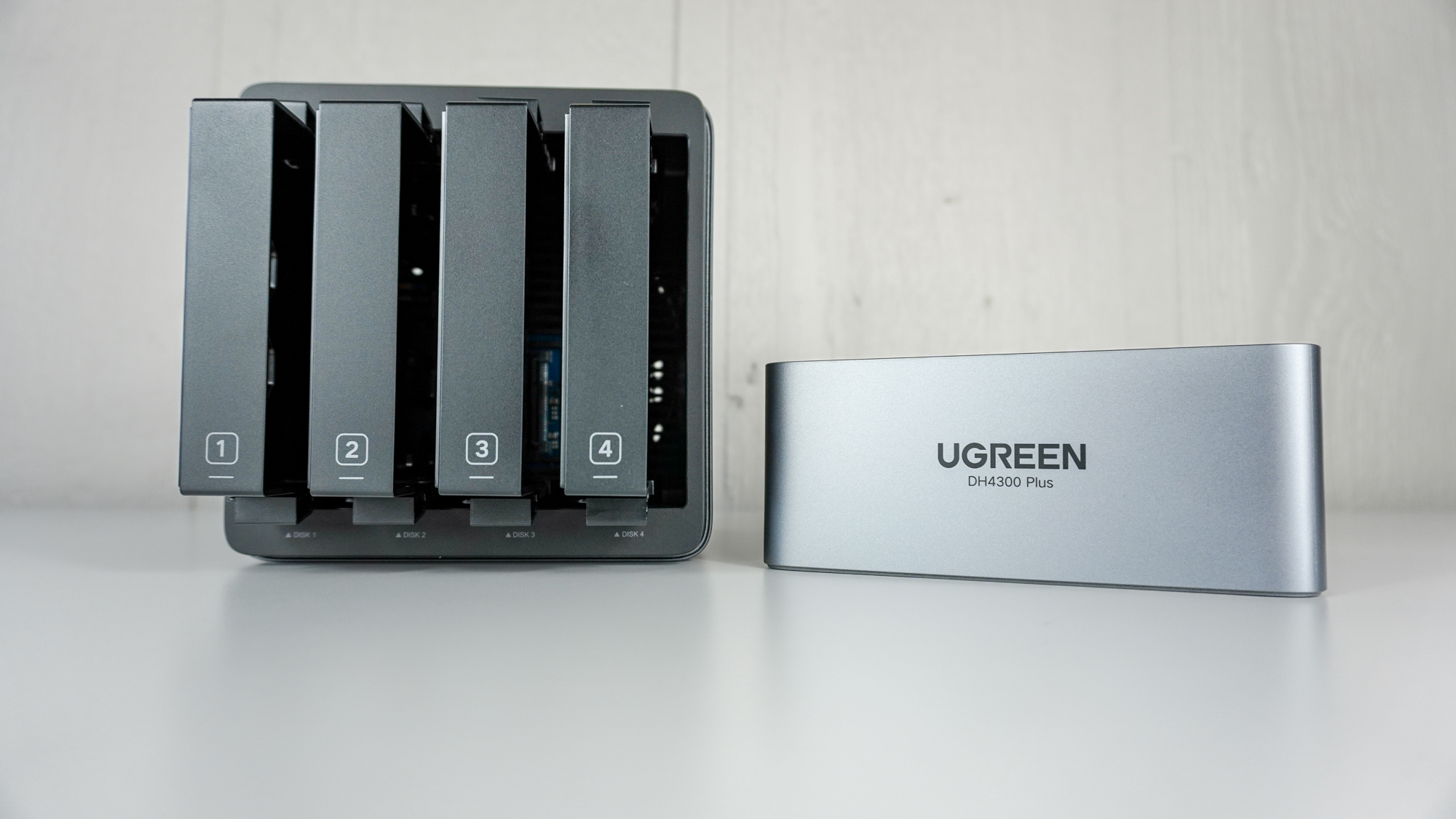 The Ugreen NASync DH4300 Plus with its magnetic top opened and it&#039;s four drive bay enclosures visible