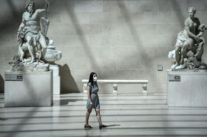 A visitor to the Louvre museum wearing a face mask.