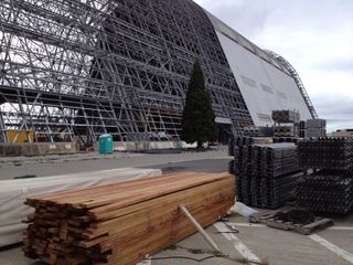 Reclaimed redwood from Hangar One at NASA's Ames Research Center is seen near the stripped down airship hangar at Moffett Field in California.