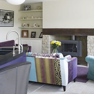 kitchen living area with purple and turquoise upholstery and logburner