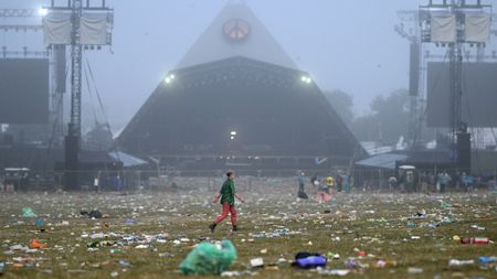 Someone walking past the main stage of Glastonbury in the early hours of the morning
