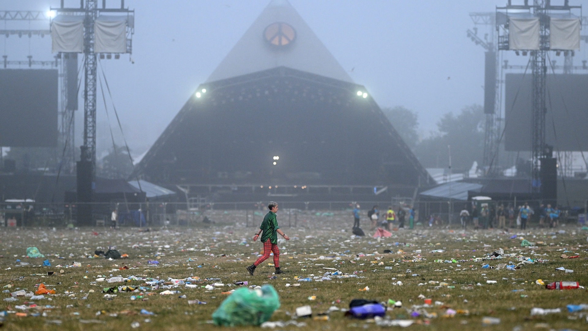 Someone walking past the main stage of Glastonbury in the early hours of the morning