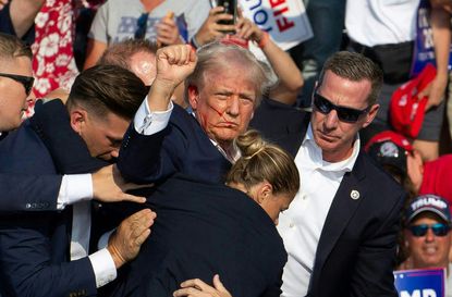 Republican candidate Donald Trump is seen with blood on his face surrounded by secret service agents as he is taken off the stage at a campaign event at Butler Farm Show Inc. in Butler, Pennsylvania