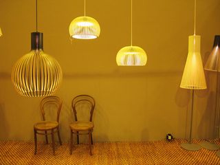 Four different designs of hanging ceiling lights in a room with two wooden chairs and textile flooring