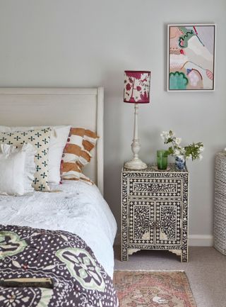Bedroom with decorative bedside table and red print lampshade