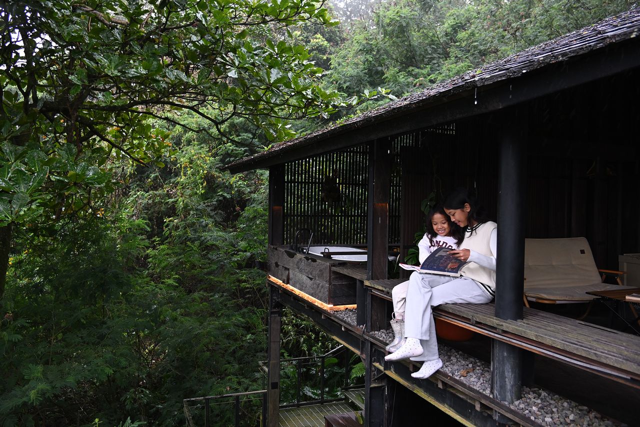Two people reading a book in a forest